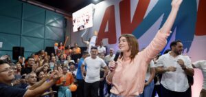 Aryel Almeida ao microfone, de braço erguido, em ato público diante de apoiadores